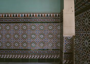 A detailed view of colorful geometric patterns on Islamic mosaic tile wall.