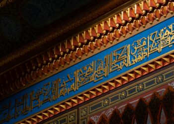 Detailed view of intricate Islamic calligraphy and decorative elements in a mosque interior in İstanbul, Türkiye.